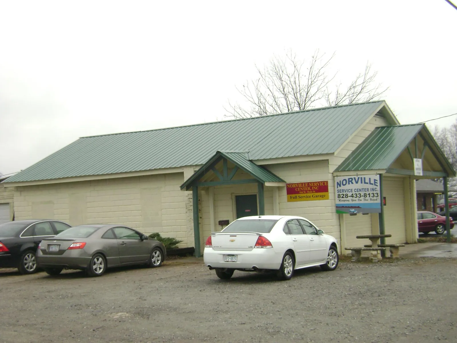 Green metal roof on a service garage with a covered entry in Proctor